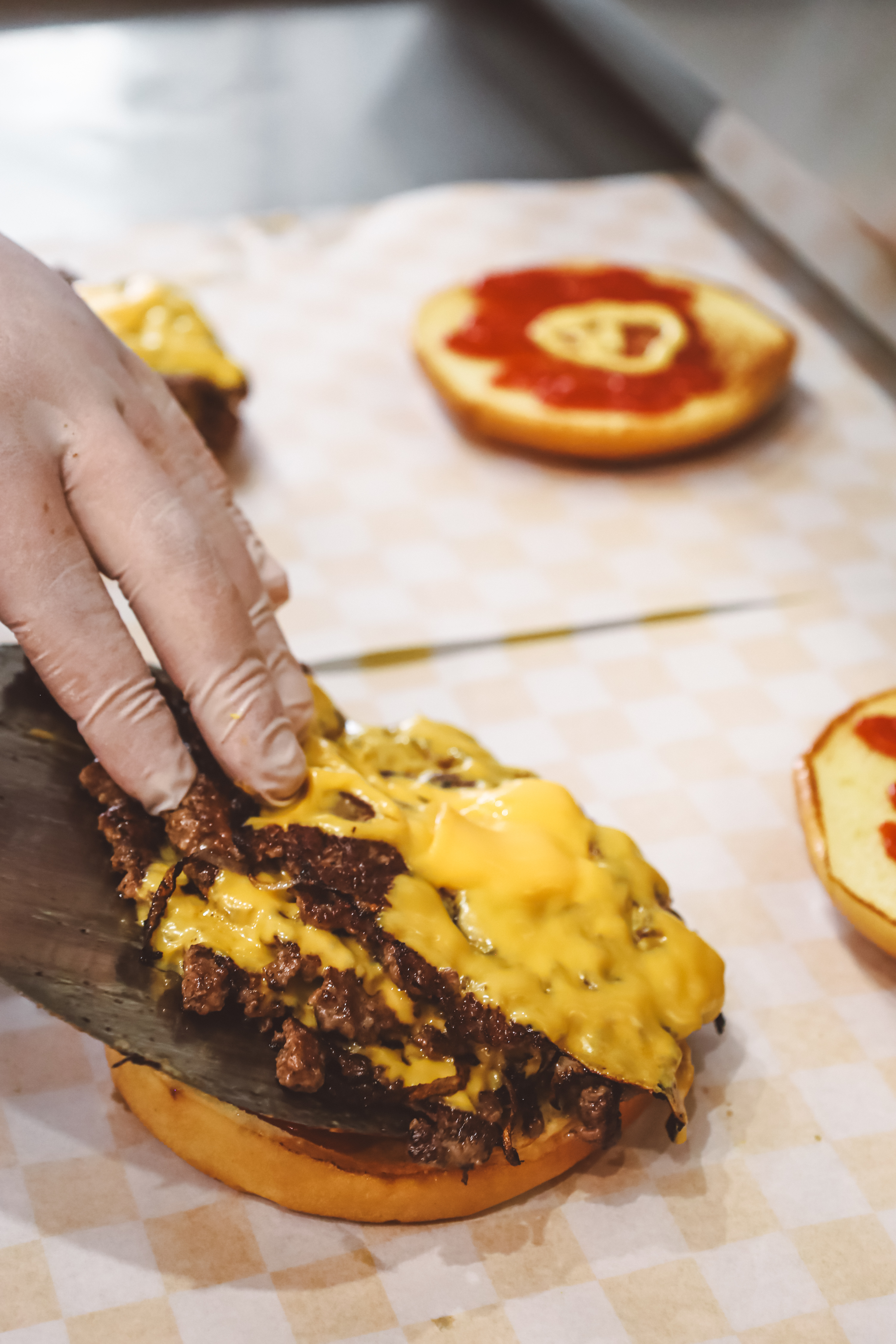 Kesztyűs kézzel készül a smash burger: húspogácsa kerül a bucira